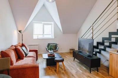 a living room with a couch and a tv at Modern Mezzanine Apt at Jecna st in Prague