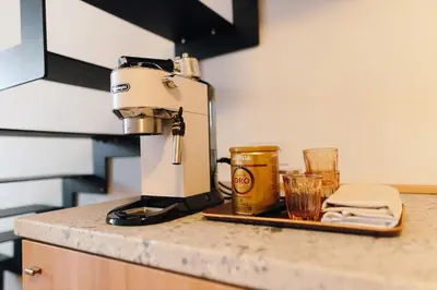 a coffee maker and two glasses on a counter at Modern Mezzanine Apt at Jecna st in Prague