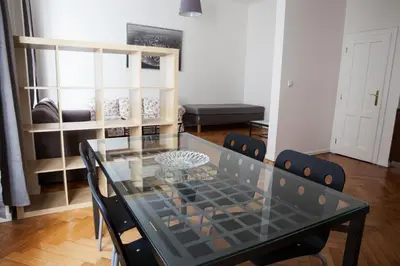 a dining room with a glass table and chairs at 2 Bed Flat - Sleeps 9 - Pets - Smoking on terrace in Prague