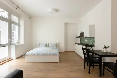 a white bedroom with a bed and a desk at Cozy Studio in quiet courtyard near Charles Bridge in Prague