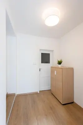 a white room with a white door and a wooden cabinet at Cozy Studio in quiet courtyard near Charles Bridge in Prague