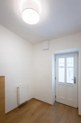 an empty room with a white door and a window at Cozy Studio in quiet courtyard near Charles Bridge in Prague