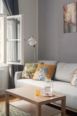 a white bedroom with a bed and a chair at Prague Days - Modern Apartments just 7 min from Wenceslas Square in Prague