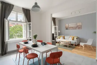 a dining room with a white table and orange chairs at Prague Days - Modern Apartments just 7 min from Wenceslas Square in Prague