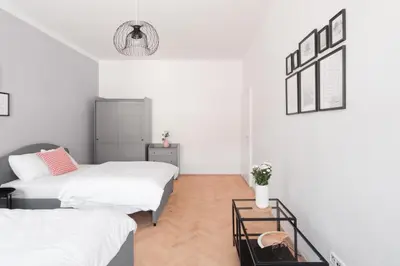 a bedroom with two beds and a table at Prague Days - Modern Apartments just 7 min from Wenceslas Square in Prague
