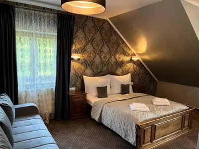 a bedroom with a bed and a window and a couch at Elodia in Choťánky