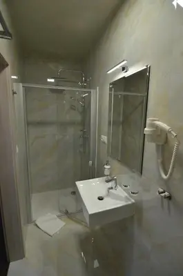 a bathroom with a sink and a shower with a mirror at Elodia in Choťánky