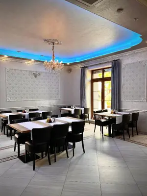 a dining room with tables and chairs and a chandelier at Elodia in Choťánky