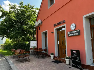 a restaurant with tables and chairs outside of a building at Elodia in Choťánky