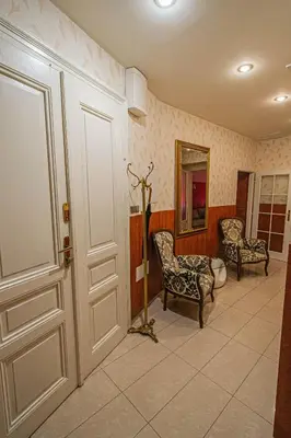 a hallway with two chairs and a mirror and a door at Central 2BDR flat behind Museum in Prague
