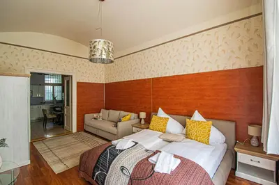a bedroom with a large bed and a couch at Central 2BDR flat behind Museum in Prague