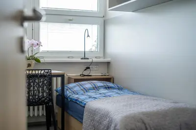 a bedroom with a bed and a desk and a window at Penzion BIG HOUSE in Prague