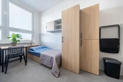 a bedroom with a bed and a desk and a cabinet at Penzion BIG HOUSE in Prague