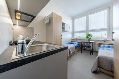 a kitchen with a sink and a bedroom with a bed at Penzion BIG HOUSE in Prague