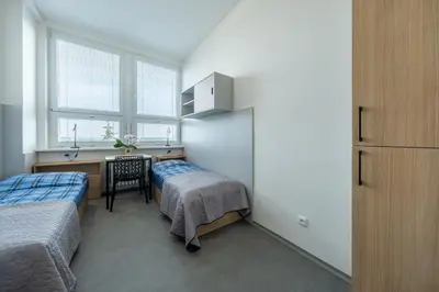 a bedroom with two beds and a desk and a table at Penzion BIG HOUSE in Prague