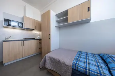 a small bedroom with a bed and a sink at Penzion BIG HOUSE in Prague