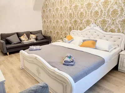 a bedroom with a white bed and a couch at Viaducto de Karlín - Aparment in Prague