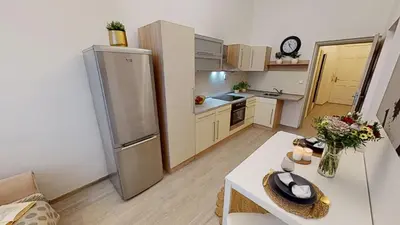 a small kitchen with a stainless steel refrigerator at Viaducto de Karlín - Aparment in Prague