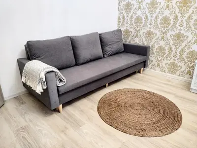 a grey couch in a living room with a rug at Viaducto de Karlín - Aparment in Prague