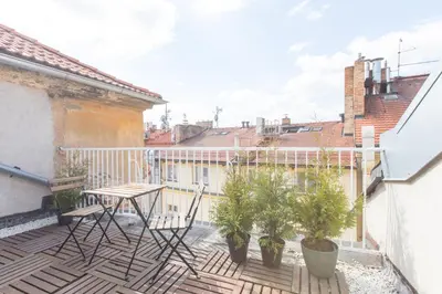 a balcony with a table and chairs on a building at Modern & Stylish Prague Apartments, Multiple Units in Prague