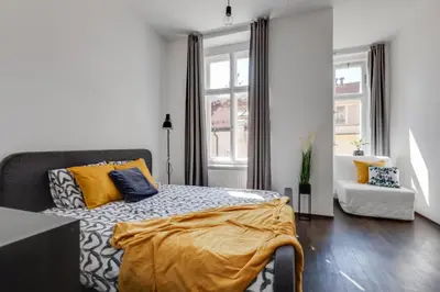 a bedroom with a bed and a chair and a window at Modern & Stylish Prague Apartments, Multiple Units in Prague
