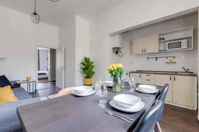 a dining room with a table and a kitchen at Modern & Stylish Prague Apartments, Multiple Units in Prague