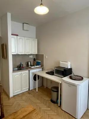 a kitchen with white cabinets and a table with a microwave at 1 Bed Flat - Sleeps 2 - Pets - Wifi in Prague