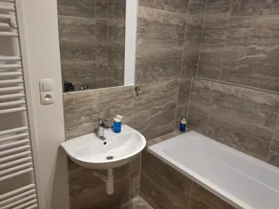 a bathroom with a sink and a bath tub at Brand new one bedroom apartment #54 in brand new building with free parking in Prague