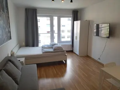 a living room with a couch and a large window at Brand new one bedroom apartment #54 in brand new building with free parking in Prague