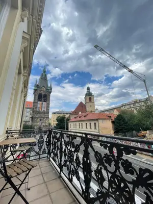 a balcony with a view of a city with a crane at Grand Viceroy Apartments - Gothic Tower View in Prague