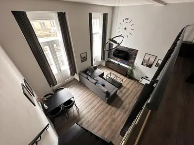 a living room with a couch and a clock on the wall at Grand Viceroy Apartments - Gothic Tower View in Prague