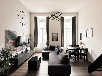 a living room with a couch and a clock on the wall at Contemporary Jindřišská Apartment in Prague