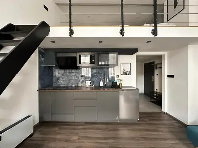 a kitchen with stainless steel appliances and a staircase at Contemporary Jindřišská Apartment in Prague