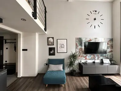 a living room with a clock on the wall at Contemporary Jindřišská Apartment in Prague