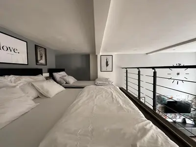 a large white bedroom with a bed and a window at Contemporary Jindřišská Apartment in Prague