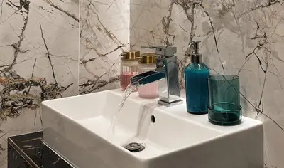 a bathroom sink with soap and bottles on it at Contemporary Jindřišská Apartment in Prague