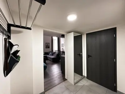 a hallway with a black door and a living room at Contemporary Jindřišská Apartment in Prague