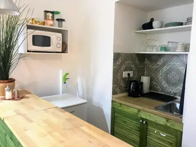 a small kitchen with a counter and a microwave at Fun Tiki Vibe Apartment / Charles Bridge / Netflix in Prague