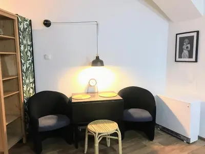 a room with a table and chairs and a lamp at Fun Tiki Vibe Apartment / Charles Bridge / Netflix in Prague