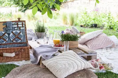 a picnic table with a blanket and a basket of fruit at Domeček na Květinovém statku in Zdice