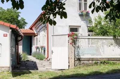 a white fence in front of a house with flowers at Domeček na Květinovém statku in Zdice