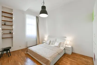 a white bedroom with a bed and a window at Klimentská 52 Residence in Prague