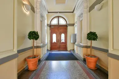 a hallway with a wooden door and three potted plants at Klimentská 52 Residence in Prague