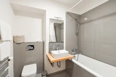 a bathroom with a sink and a toilet and a tub at Klimentská 52 Residence in Prague