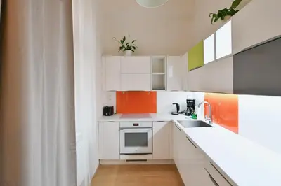 a small kitchen with white cabinets and a sink at Klimentská 52 Residence in Prague