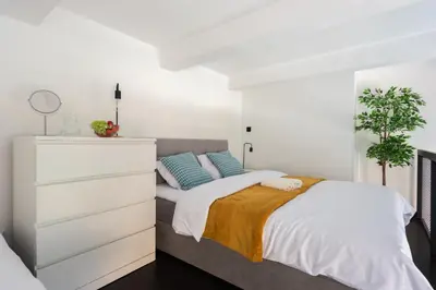 a white bedroom with a bed and a dresser at Loft spacious apartments in Prague in Prague