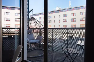 a balcony with a chair and a view of a building at Loft spacious apartments in Prague in Prague