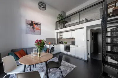 a kitchen and living room with a table and chairs at Loft spacious apartments in Prague in Prague