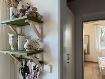 a hallway with green shelves with teddy bears and vases at DIVADELNÍ PENZION in Bukovany