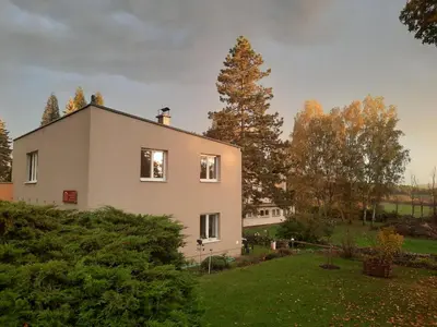 a white house with a tree in the background at DIVADELNÍ PENZION in Bukovany